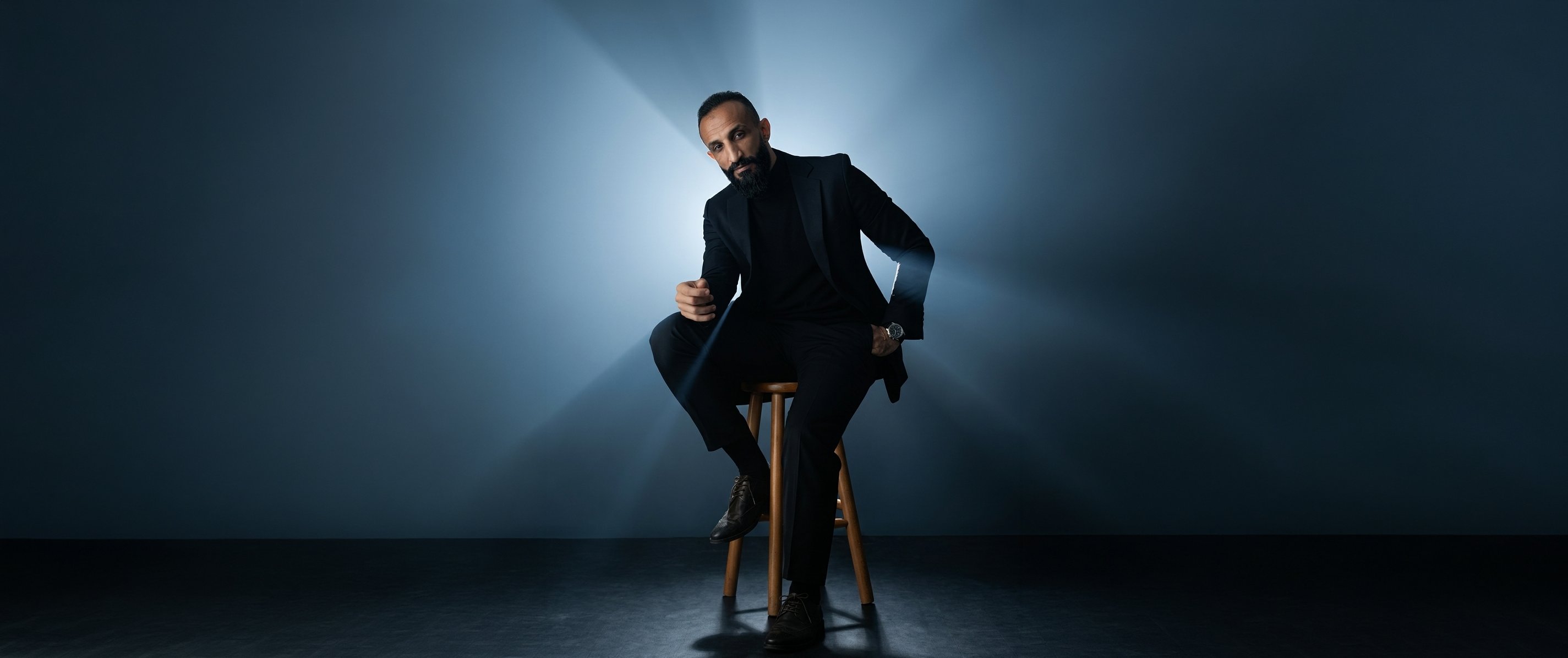Yasir Saad — Post Production Specialist, seated in cinematic blue-lit studio